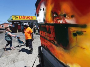 A mural by an artist known as Nery is seen in front of Tom's Liquor at the corner of Florence and Normandie, the flash point of the riots that erupted after the 1992 acquittal of four white police officers in the beating of black motorist Rodney King, on the 25th anniversary, in Los Angeles, Saturday, April 29, 2017. (AP Photo/Reed Saxon)