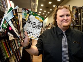 Chris Runciman, a manager at Heroes comics book store in London, shows some of the titles published by Runciman Press, a business started by Runciman and his wife, Lori, two years ago. (MORRIS LAMONT, The London Free Press)