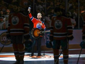 Canadian country singer Brett Kissel holds his faulty microphone asking the crowd to sing the "Star-Spangled Banner" before the start of the Anaheim Ducks and the Edmonton Oilers NHL hockey round two playoff hockey game in Edmonton, Sunday, April 30, 2017.