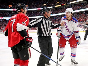 A linesman holds apart Kyle Turris and Brendan Smith during Game 2 between the Ottawa Senators and New York Rangers on April 29, 2017. (Wayne Cuddington/Postmedia)