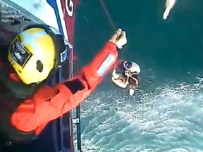 This image taken from video issued by the Maritime & Coastguard Agency on Tuesday May 2, 2017, shows the rescue of surfer Matthew Bryce.  (Maritime & Coastguard Agency via AP)