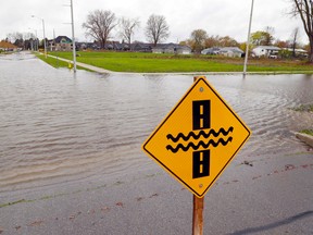 A sign warns of flooding at the intersection of Harbour Drive, left, and George Street Tuesday, May 2, 2017 in Belleville, Ont. Flooding has closed some city routes as well as affected basements. Luke Hendry/Belleville Intelligencer/Postmedia Network