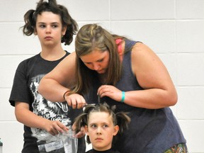 A student from St. Anthony School donates her hair for Shave to Save. Photo taken in 2015.