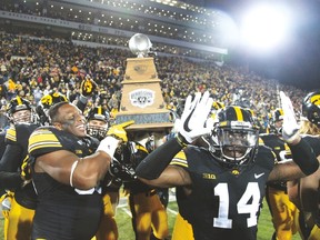 Defensive lineman Faith Ekakitie and defensive back Desmond King of the Iowa Hawkeyes celebrate with the Heroes Trophy on Nov. 25, 2016 at Kinnick Stadium in Iowa City, Iowa. (Matthew Holst/Getty Images)