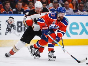 Anaheim Ducks' Corey Perry, left, checks Edmonton Oilers' David Desharnais during third period NHL hockey round two playoff action in Edmonton, Sunday, April 30, 2017.