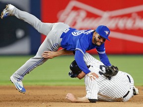 Toronto Blue Jays second baseman Devon Travis falls over New York Yankees' Chase Headley, who was out at second, on a double play hit into by Yankees' Matt Holliday during the sixth inning in New York, May 2, 2017. (KATHY WILLENS/AP)