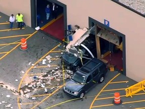 This still image from video provided by NBC Boston shows wreckage after a vehicle suddenly accelerated at an auto auction and struck several people before it crashed through a wall of the building, Wednesday, May 3, 2017, in Billerica, Mass. (NBC Boston via AP)