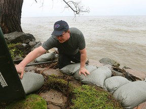 Rob Bauman arranges sandbags along the banks of Lake Ontario on property that belongs to his parents on Edgemere Dr., in Greece, N.Y. May 2, 2017. Four months after an international body adopted new rules for regulating Lake Ontario's water levels, property owners who had claimed the rules favored muskrat lodges over lakeside homes are being battered by just the sort of waves they had predicted. (Jamie Germano/Democrat & Chronicle via AP)