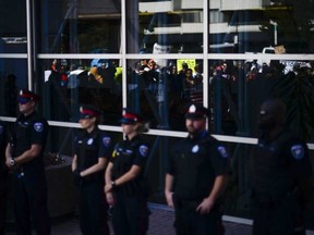 Demonstrators are reflected on the windows of the Ottawa police headquarters as they shout and chant for justice at Ottawa police headquarters during the March for Justice - In Memory of Abdirahman Abdi, on Saturday, July 30, 2016. JAMES PARK / POSTMEDIA