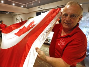 Bob Harper, of Brockville displays the only Peace Tower Canadian Flag signed by one of its principal proponents, John Ross Matheson. The flag is being auctioned off to promote to promote flag education. (MICHAEL PEAKE/TORONTO SUN)