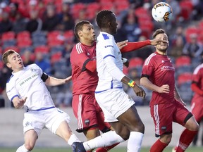 Ottawa’s Steevan Dos Santos (centre) eyes the ball as it pops into the air in front of Edmonton’s Pape Diakite during last night’s game. Fury FC won the matchup 1-0. (JULIE OLIVER/Postmedia Network)