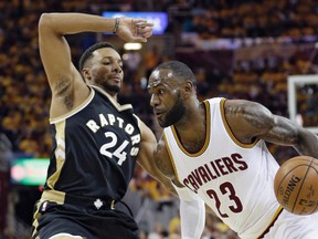 Cleveland’s LeBron James (right) drives against Norman Powell of the Raptors last night in Game 2 of the teams’ second-round NBA playoff series. (AP PHOTO)