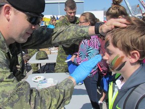 In this file photo, trooper Macauley Clegg applies camouflage paint to the face of Iain Thompson, a  student at Queen Elizabeth II Public School in Petrolia, during last year's Emergency Preparedness Day at the Clearwater Arena in Sarnia, Ont. This year's Emergency Preparedness Day returns to the area Friday, 9 a.m. to 2 p.m. (File photo)