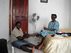 Marie Lourdes, who has been the pastor of a church in a rural mountain community in Haiti for 26 years, massages an elderly woman's swollen feet, immediately after having experienced her own first massage. (Supplied photo)