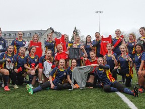 Members of the Napanee Golden Hawks girls rugby team show off the shirts, cleats, shorts and other gifts they received from alum Brittany Benn, a Napanee native, at Nixon Field. (Julia McKay/The Whig-Standard)