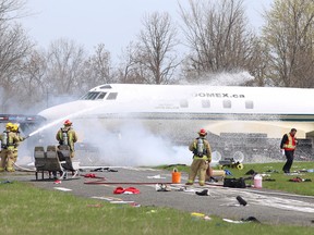Kingston firefighters spray foam at the scene of a training exercise at the Norman Rogers Airport in Kingston that simulated a plane crash. (Elliot Ferguson/The Whig-Standard)