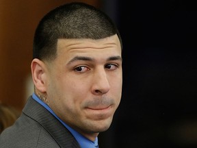 In this April 14, 2017, file pool photo, former New England Patriots tight end Aaron Hernandez turns to look in the direction of the jury as he reacts to his double murder acquittal after the sixth day of jury deliberations at Suffolk Superior Court in Boston.  (AP Photo/Stephan Savoia, Pool)