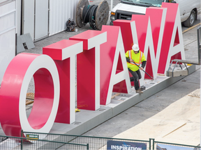 Workers are seen installing the OTTAWA sign at Inspiration Village on York St in the ByWard Market, part of the Ottawa 2017 celebrations, opening on May 20 and running until September 4. (Wayne Cuddington, Postmedia)
