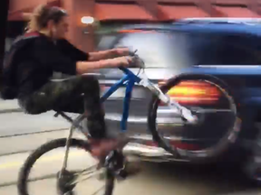 Video of a wheelie-popping cyclist weaving in and out of downtown Toronto traffic is gaining traction on social media. (Facebook)