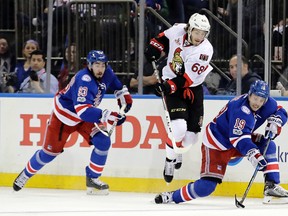 Rangers' Jesper Fast (right) fights for control of the puck with Senators' Mike Hoffman (centre) as Mika Zibanejad (left) watches during second period NHL playoff action in New York on Thursday, May 4, 2017. (Frank Franklin II/AP Photo)