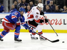 Rangers' Nick Holden (left) and Senators' Mark Stone (right) reach for the puck during Game 3 of their NHL playoff series in New York on Tuesday, May 2, 2017. (Frank Franklin II/AP Photo)