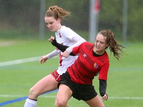 Medway's Melissa Siroen fends off Brianne Shore of the Oaks during their rain soaked game on one of Western's artificial turf fields on Friday May 5, 2017. Despite the pouring rain and wind both teams fought hard with the Oaks coming out on top 4-1. (MIKE HENSEN, The London Free Press)