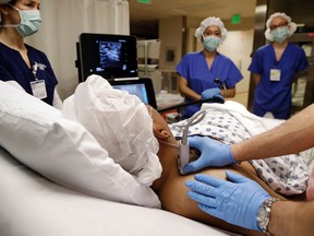 In this photo taken Feb. 15, 2017, anesthesiologist Dr. Ron Samet examines an ultrasound image while performing a nerve block at the University of Maryland Medical Center. Bathing specific nerves in a numbing drug allows many patients to avoid or reduce use of potentially addictive painkillers after surgery, one way hospitals are reducing their own dependence on opioids.  (AP Photo/Patrick Semansky)