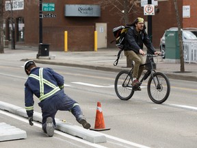 Workers install the downtown bike lane network on May 1, 2017. Ian Kucerak /Postmedia