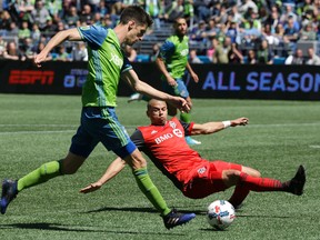 Toronto FC defender Jason Hernandez tries to block a shot by Seattle Sounders midfielder Alvaro Fernandez on Saturday. (AP)