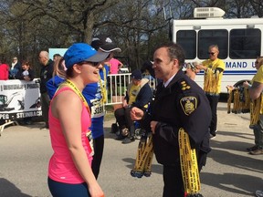 Police Chief Danny Smyth hands out medals at the finish line of the 13th annual Winnipeg Police Service Half Marathon on Sunday, May 7, 2017, at Assiniboine Park in Winnipeg. Handout/Winnipeg Police Service