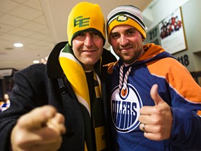 Josh Buchanan, left, and Simon Grindke, right, show off their Edmonton Oilers and Eskimos garb at Rexall Place in Edmonton on Nov. 16, 2014. (File)