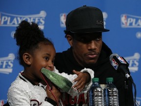 Raptors’ DeMar DeRozan with daughter Diar, biting her sparkly watermelon purse, speaks to the media after being eliminated. (Jack Boland/Postmedia Network)