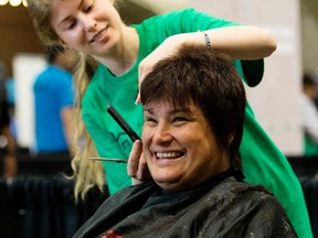 Theresa Baron smiles as she receives a haircut from MC College volunteer Alicia Molzahn during the 18th annual Homeless Connect event at the Shaw Conference Centre, in Edmonton Sunday May 7, 2017. Approximately 2,000 people were expected to take part in the event which provided health care, dental care, counselling, legal services, employment information, and housing resources. Photo by David Bloom