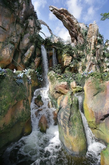In this Saturday, April 29, 2017 photo, landscaping consisting of real Earth plant species mixed with sculpted Pandora artificial flora is surrounded by ponds and gentle waterfalls at the Pandora-World of Avatar land attraction in Disney's Animal Kingdom theme park at Walt Disney World in Lake Buena Vista, Fla. The 12-acre land, inspired by the “Avatar” movie, opens in Florida at the end of May at Walt Disney World’s Animal Kingdom. It cost a half-billion dollars. (AP Photo/John Raoux)