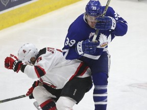 Albany Devils Karl Stollery (7) lays a solid hip check on Toronto Marlies Frederik Gauthier (33) during the third period of AHL first-round playoffs in Toronto on April 27, 2017. (Jack Boland/Toronto Sun)