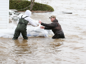 Sand bags are brought to help stop the Ottawa river from flooding cottages on Wilson Road in Rockland. (Jean Levac, Postmedia)