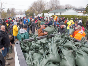 All sorts of volunteers are pitching in with sandbagging at Rue Saint-Louis and Rue Moreau in Gatineau as flooding continues throughout the region in areas along the local rivers.  (Wayne Cuddington, Postmedia)