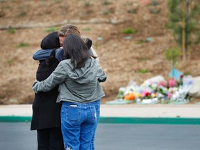 People gather at Torrey Pines High School on Sunday, May 7, 2017, in San Diego, near a memorial for a 15 year-old student that was shot and killed by police in the parking lot the day before. (K.C. Alfred /The San Diego Union-Tribune via AP)