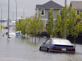 Cars sit parked in flood water in a restricted neighborhood in High River, Alta., Thursday, July 4, 2013. THE CANADIAN PRESS/Jeff McIntosh