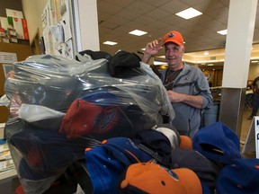 Reid Snell gets a hat that was dropped off at the Hope Mission by the Edmonton Oilers Foundation, after hats were thrown on the ice after Leon Draisaitl scored his hat trick goal against the Anaheim Ducks. Taken on Monday May 8, 2017, in Edmonton. Greg Southam / Postmedia