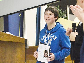 Nathan Larson receives an award from the local chapter of Autism Ontario, a token of appreciation for his effort during April. Larson raised $400 for the chapter as part of a school project where students are encouraged to use their talents to benefit the community.