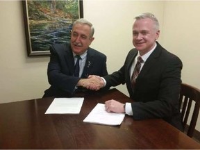 Ottawa Police Services Board chair Coun. Eli El-Chantiry and Ottawa Police Association president Matt Skof handshake on a tentative collective agreement for police officers on Tuesday, May 9, 2017. -