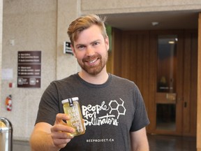 Chris Kirouac, co-founder of Beeproject Apiaries, displays a jar of honey on May 9, 2017, made with downtown Winnipeg beehives. Kirouac said residential areas could suit beehives and supports an expansion of hives across the city. (JOYANNE PURSAGA/Winnipeg Sun/Postmedia Network)