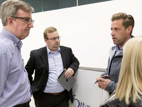 Ottawa Mayor Jim Watson, left, and Cumberland Ward Coun. Stephen Blais talk with André Morin and his partner Amanda Joanis, who own a house on Petrie Island, following a disaster recovery information session at the R.J. Kennedy Community Hall. ERROL MCGIHON /POSTMEDIA