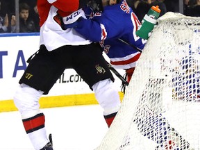 Rangers’ Brendan Smith grabs hold of the Senators’ Mark Stone during the first period in New York last night.  (Getty Images)