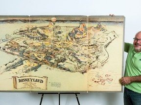 In this April 28, 2017, photo art dealer Mike Van Eaton stands next to a hand-drawn map from 1953 that shows Walt Disney's original ideas for Disneyland displayed at the Van Eaton Galleries in Sherman Oaks area of Los Angeles. Van Eaton Galleries announced that the map is the highlight among dozens of Disney items being auctioned on June 25. (AP Photo/Damian Dovarganes)