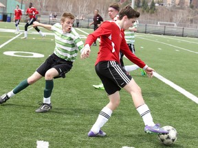 Josh Cattapan of the Lockerby Vikings battles for the ball with Adam Szalai of the St. Charles Cardinals during junior boys high school soccer action in Sudbury, Ont. on Thursday April 27, 2017. The game ended in a 1-1 tie.Gino Donato/Sudbury Star/Postmedia Network