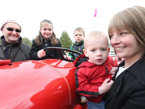 Michael Thompson will drive his tractor across Ontario in the hopes of raising money for Jillian O'Connor's kids' education, May 10, 2017.  The kids, Myla (2nd for L), Landon (m) and Declan (2nd for R) have fun looking at the tractor that Michael Thompson (L) will be driving around Ontario to raise money for their mother, Jillian O'Connor (R)  who has breast cancer.  Jillian has breast cancer.   Photo by Jean Levac