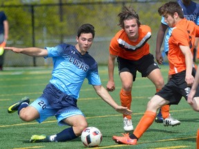Lucas player Ardin Hajdarpasic, left, slides in to play the ball with Clarke Road players Joel Bentley, centre, and Mike Terracina during a TVRAA boys soccer game at City Wide Field on Wednesday May 10, 2017. Clarke Road won by a score of 1-0. (MORRIS LAMONT, The London Free Press)