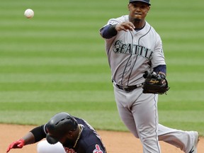 Seattle Mariners' Jean Segura (right) throws to first base after getting Cleveland Indians' Abraham Almonte out at second base in the fourth inning on April 29, 2017. (TONY DEJAK/AP files)